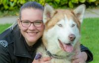 Member of staff hugging a large dog